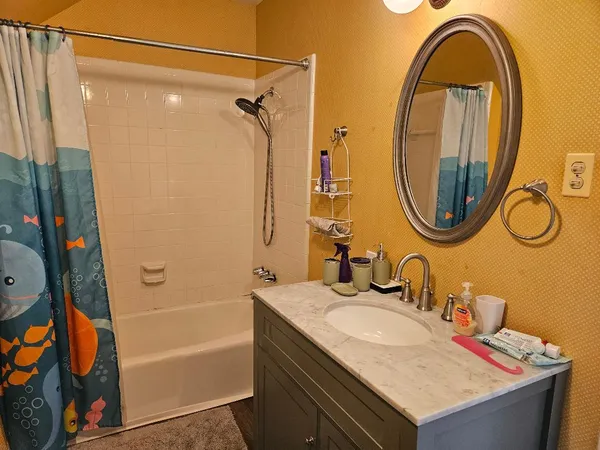 a bathroom with a granite countertop sink and a mirror
