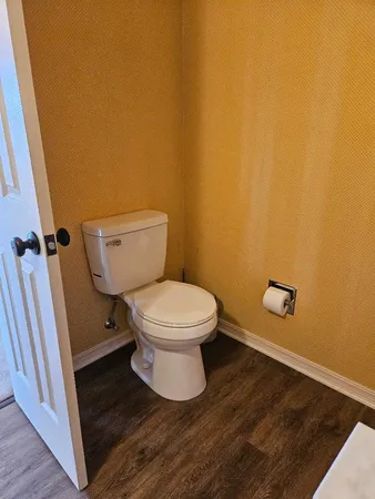 a white toilet sitting in a bathroom next to a sink