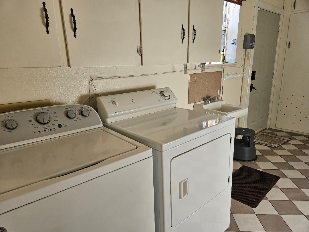 710 North Avenue C Elgin, TX 78621 - Photo 26 of 32 Laundry room with light floors, cabinet space, and independent washer and dryer