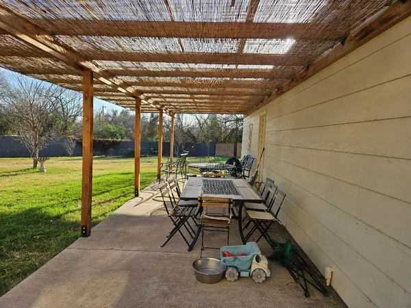 a view of a patio with table and chairs next to a yard