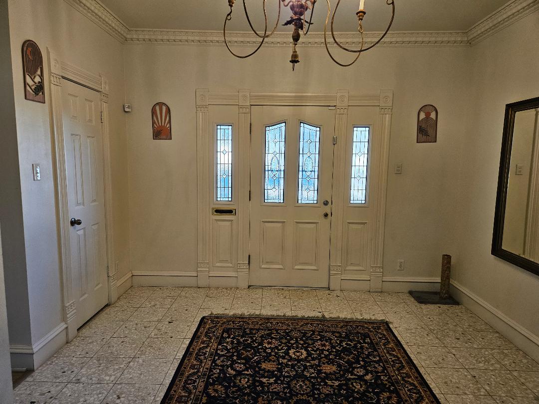 710 North Avenue C Elgin, TX 78621 - Photo 3 of 32 Entryway featuring ornamental molding and a chandelier