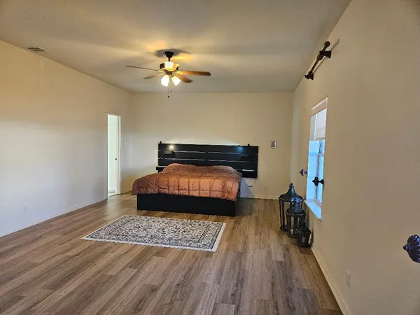 a living room with a bed furniture and a wooden floor
