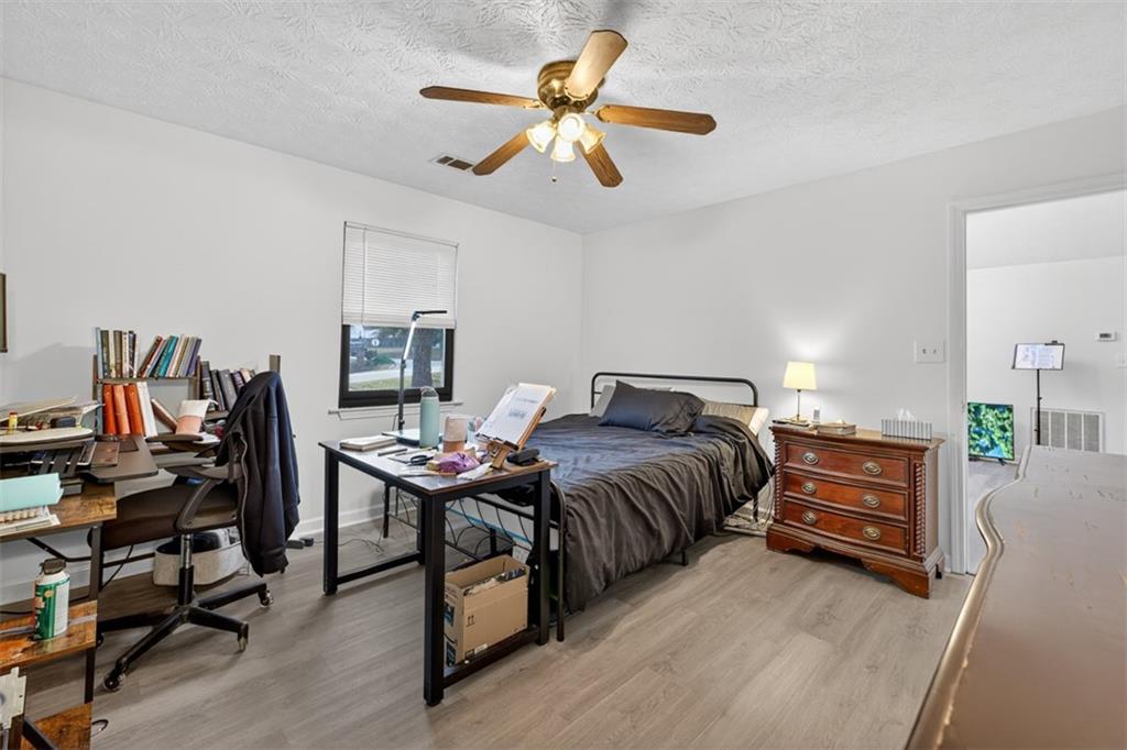 494 Spring Street Social Circle, GA 30025 - Photo 16 of 21 a bedroom with a bed and a chandelier