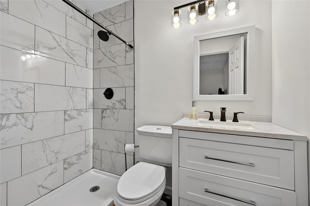 494 Spring Street Social Circle, GA 30025 - Photo 18 of 21 a bathroom with a sink a toilet and shower