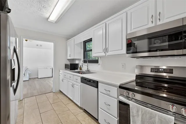 a kitchen with stainless steel appliances granite countertop a stove a refrigerator and a microwave