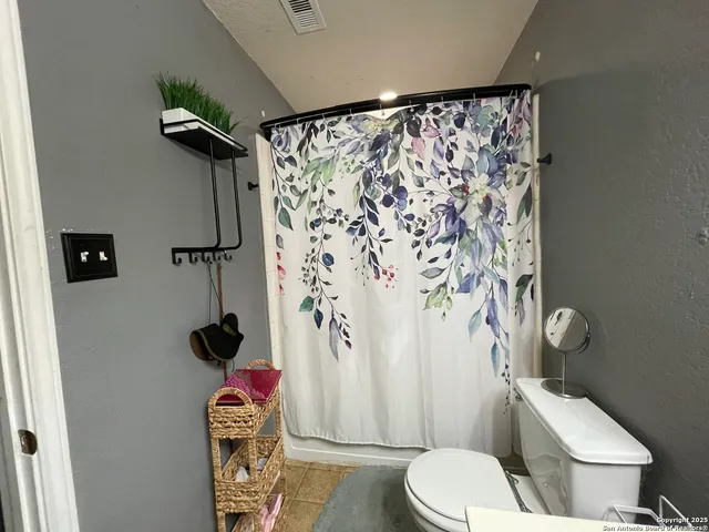 a white toilet sitting next to a shower curtain