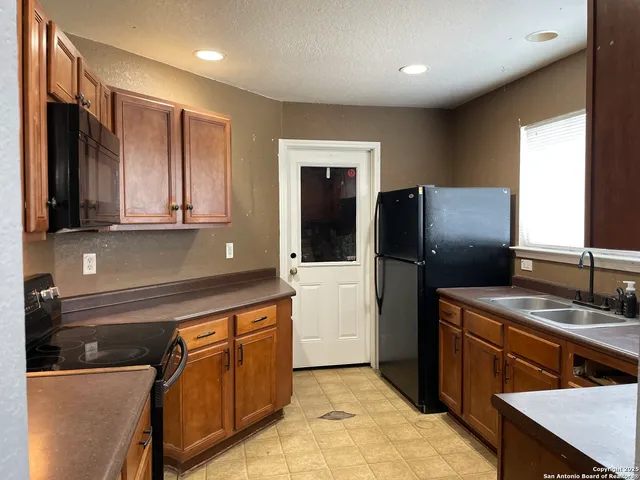 a kitchen with stainless steel appliances granite countertop a refrigerator and a sink