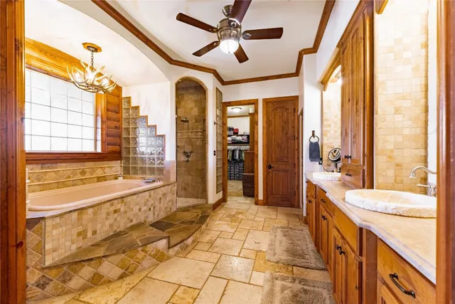 a spacious bathroom with a granite countertop sink a large mirror and a bathtub