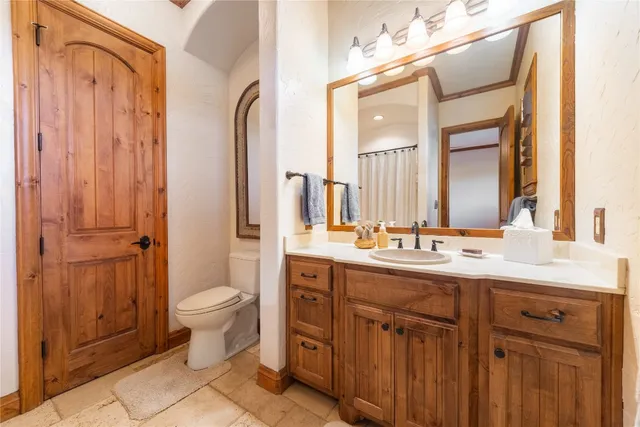 a bathroom with a double vanity sink mirror and toilet