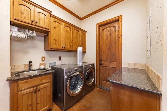 a utility room with stainless steel appliances granite countertop a stove top oven a sink and dishwasher