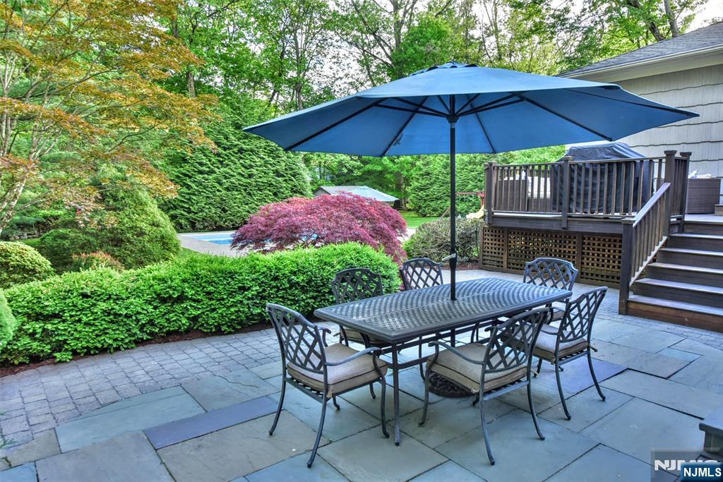 60 Dimmig Road Upper Saddle River, NJ 07458 - Photo 8 of 40 a patio table and chairs under an umbrella
