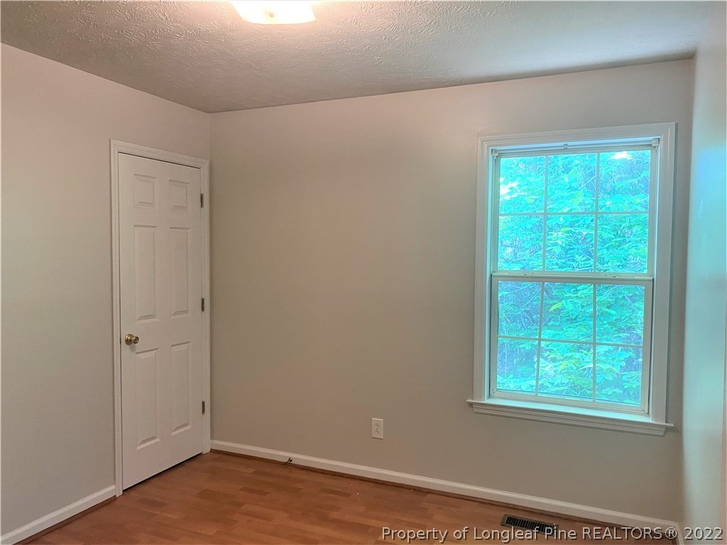 1298 Roundabout Road Cameron, NC 28326 - Photo 17 of 29 a view of an empty room with wooden floor and a window
