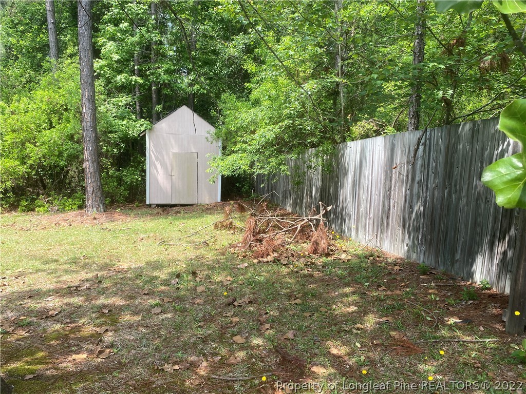 1298 Roundabout Road Cameron, NC 28326 - Photo 27 of 29 a backyard of a house with large trees and wooden fence