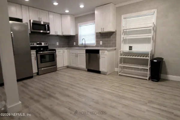 a kitchen with granite countertop a refrigerator and a stove top oven