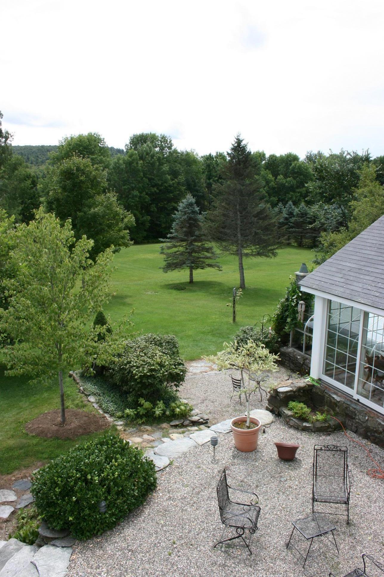 50 River Road Worthington, MA 01098 - Photo 22 of 39 a view of a backyard with couches plants and large trees