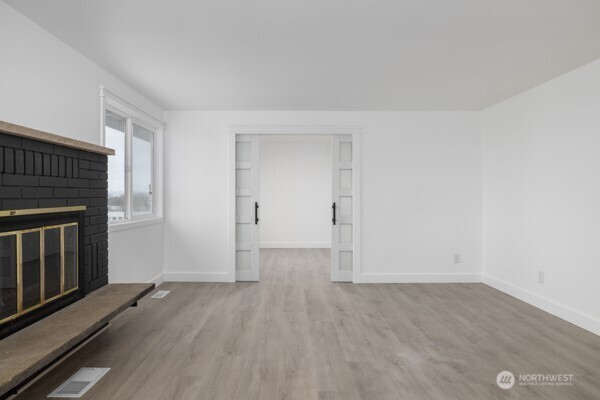 11586 Scott Road Bow, WA 98232 - Photo 27 of 28 wooden floor in an empty room with a fireplace