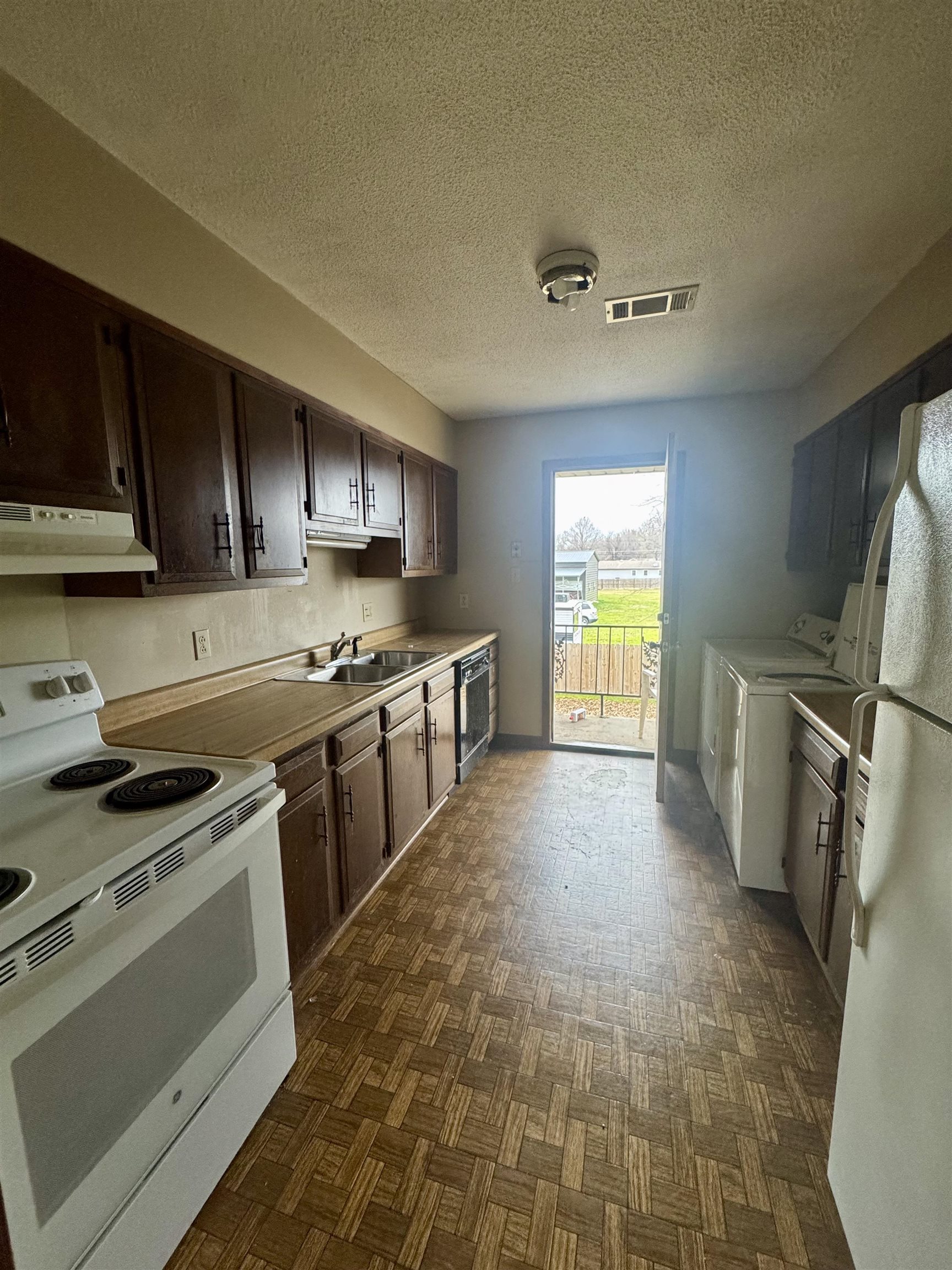 112 Halliburton Street Ripley, TN 38063 - Photo 2 of 5 a kitchen with stainless steel appliances granite countertop a stove a sink and a refrigerator