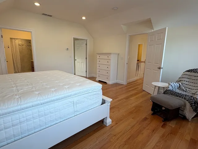 a spacious bedroom with a bed and a chair