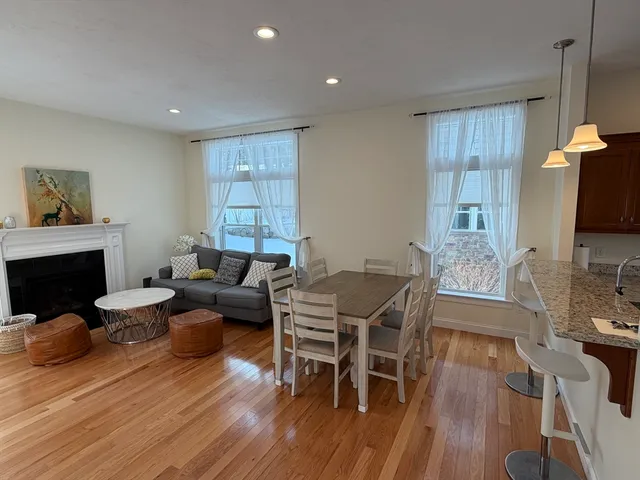 a living room with furniture a fireplace a flat screen tv and wooden floor