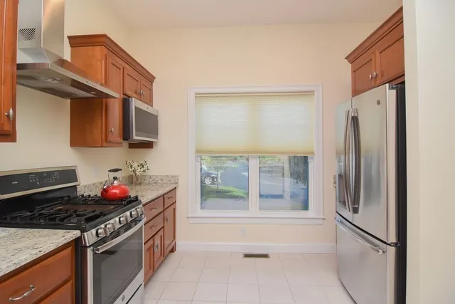 a kitchen with stainless steel appliances granite countertop a stove a refrigerator and a stove top oven