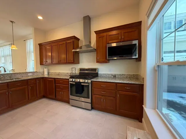 a kitchen with stainless steel appliances granite countertop a stove a sink and a microwave