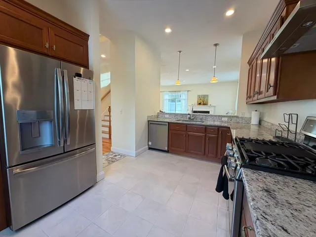 a kitchen with stainless steel appliances granite countertop a refrigerator sink and stove