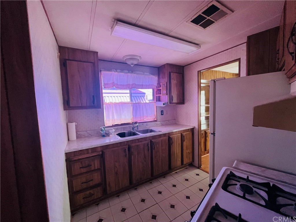 16601 Garfield Avenue, Unit 128 Paramount, CA 90723 - Photo 12 of 32 a kitchen with a sink stove and cabinets