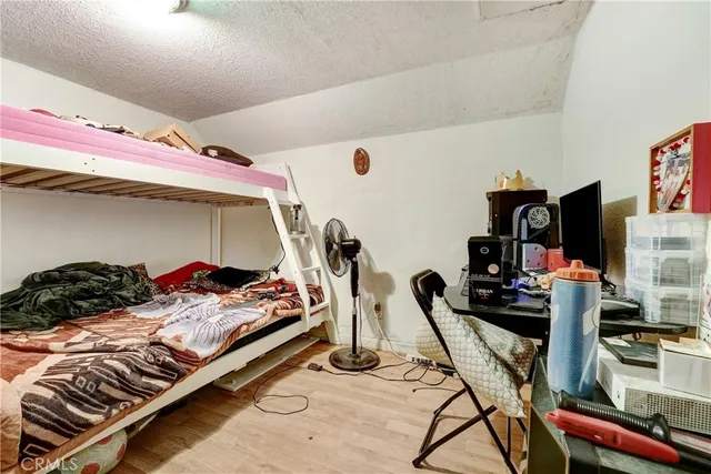 a bedroom with bed and flat tv screen on the dresser
