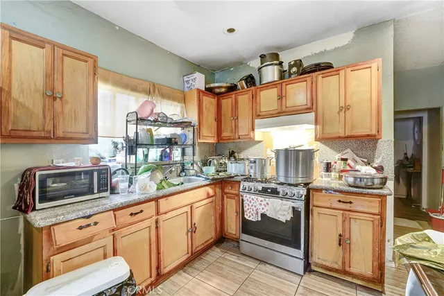 a kitchen with a sink stove top oven and cabinets