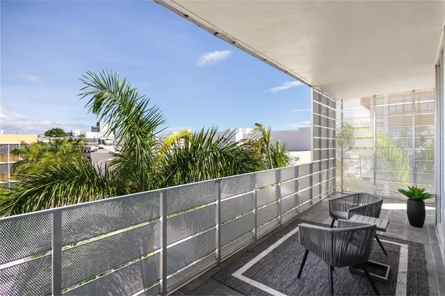 a balcony with table and chairs potted plants
