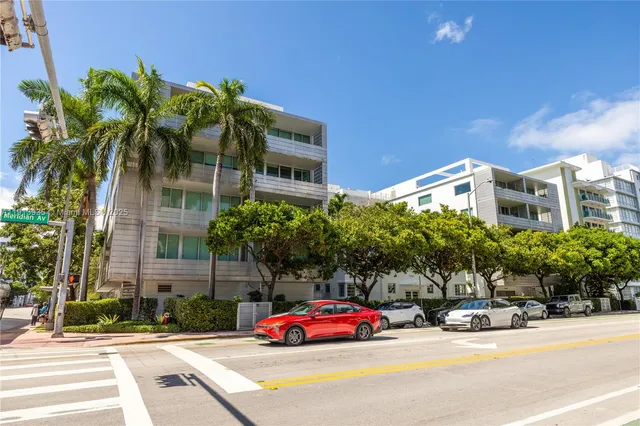 an aerial view of multi story residential apartment building with yard and outdoor seating