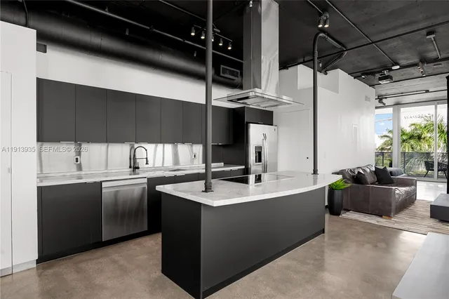 a large kitchen with stainless steel appliances granite countertop a stove and a refrigerator