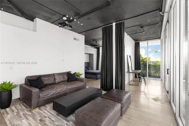 a living room with furniture and a floor to ceiling window