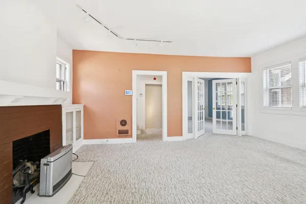 a view of a livingroom with an empty space and a fireplace
