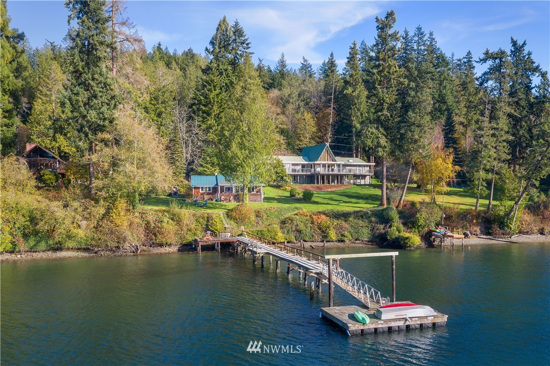 21005 Indianola Road Northeast Poulsbo, WA 98370 - Photo 1 of 40 a view of a lake with boats and trees in the background