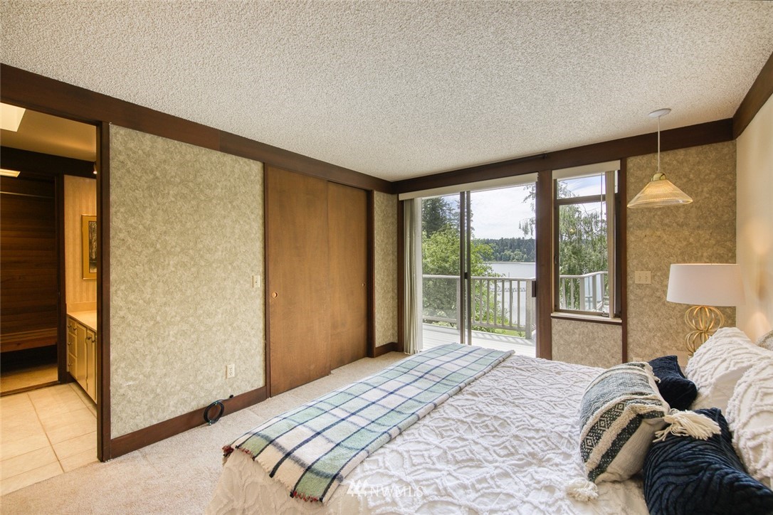 21005 Indianola Road Northeast Poulsbo, WA 98370 - Photo 17 of 40 a bedroom with a bed and a large window with outer view