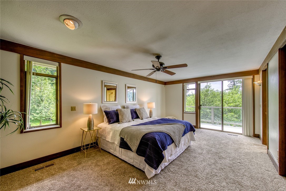 21005 Indianola Road Northeast Poulsbo, WA 98370 - Photo 20 of 40 a bedroom with a large bed and a window