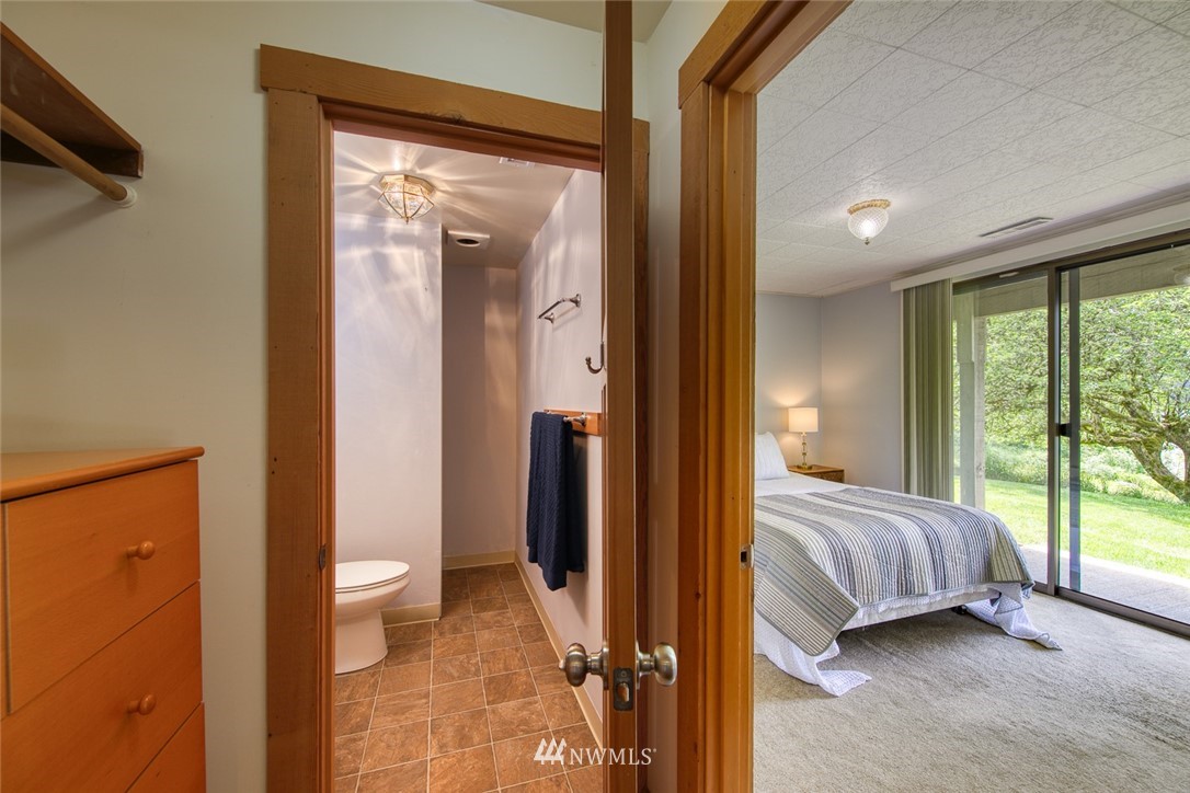 21005 Indianola Road Northeast Poulsbo, WA 98370 - Photo 29 of 40 a view of a bedroom with a bed and glass door