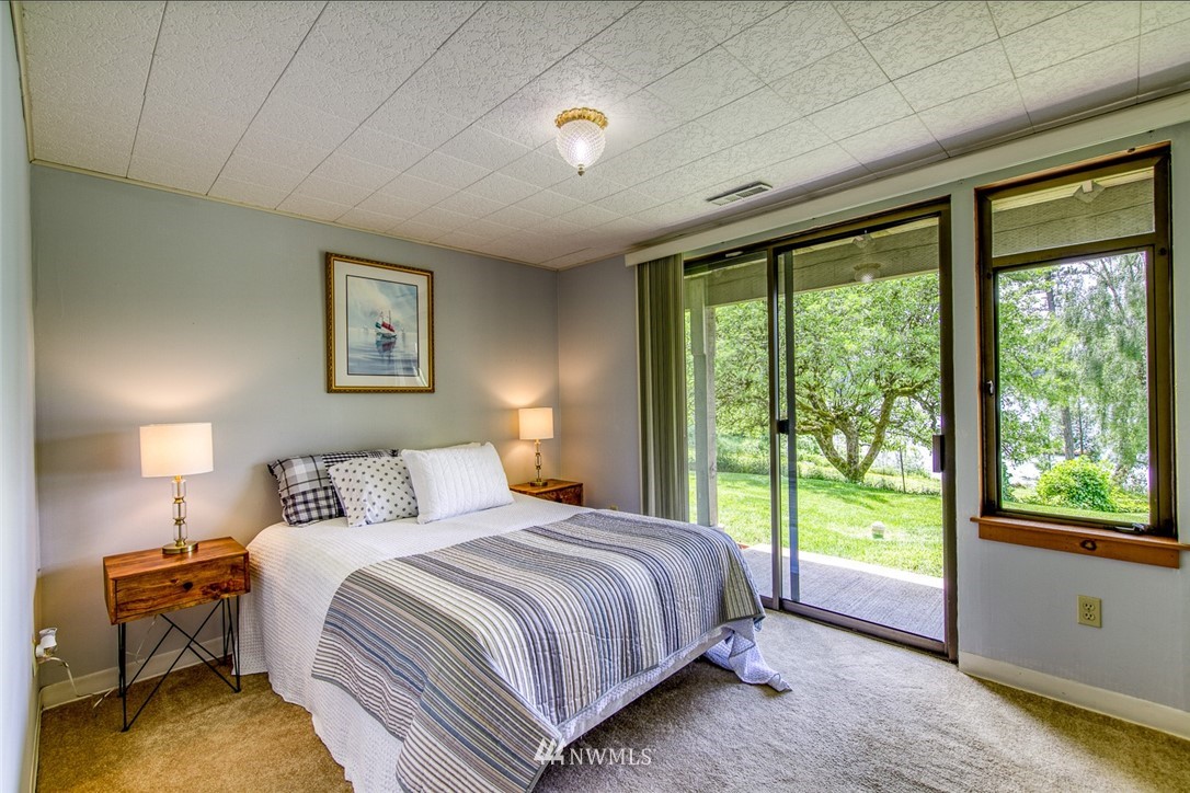 21005 Indianola Road Northeast Poulsbo, WA 98370 - Photo 30 of 40 a bedroom with a bed and a large window