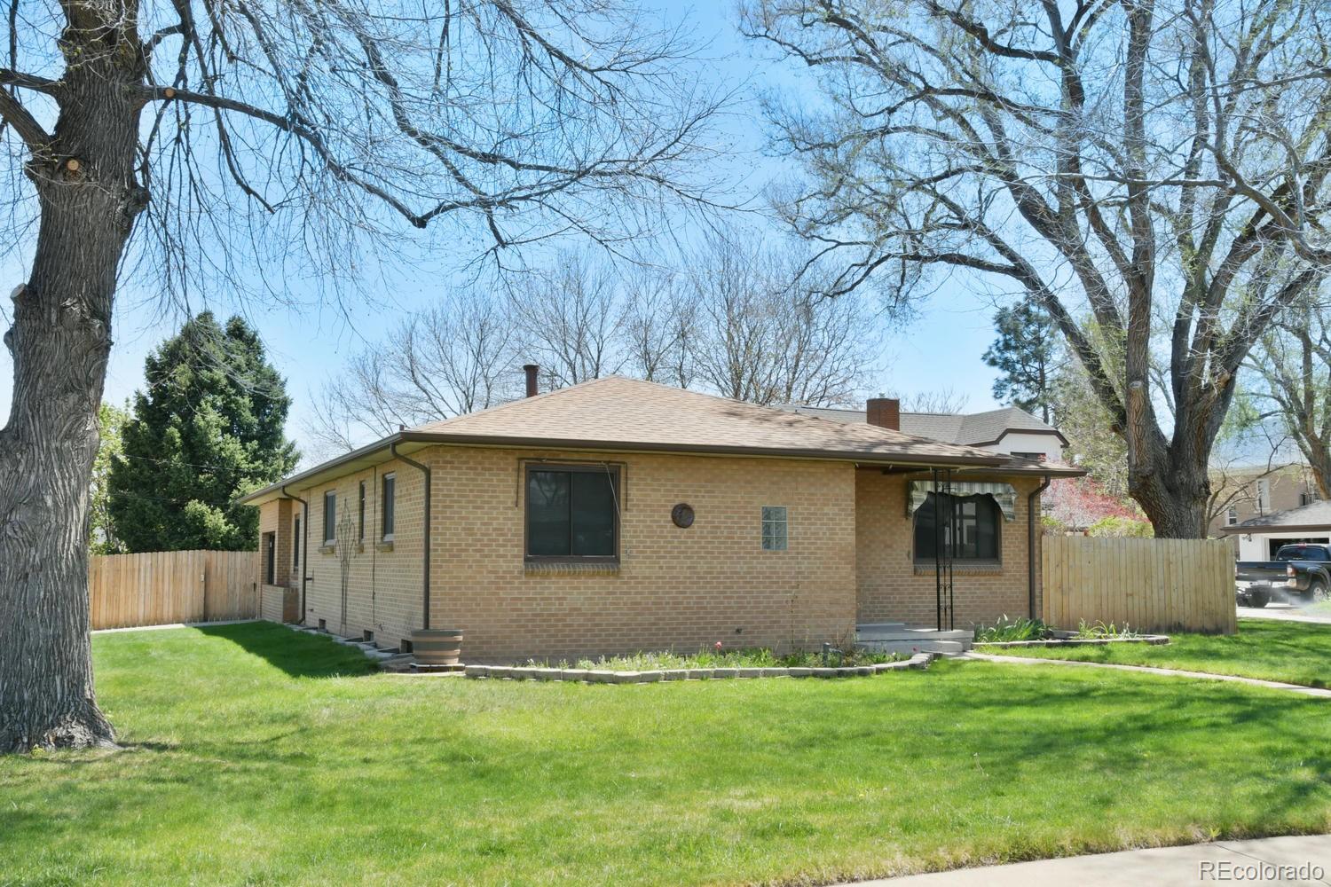 4660 Quay Street Wheat Ridge, CO 80033 - Photo 1 of 37 a backyard of a house with plants and large tree