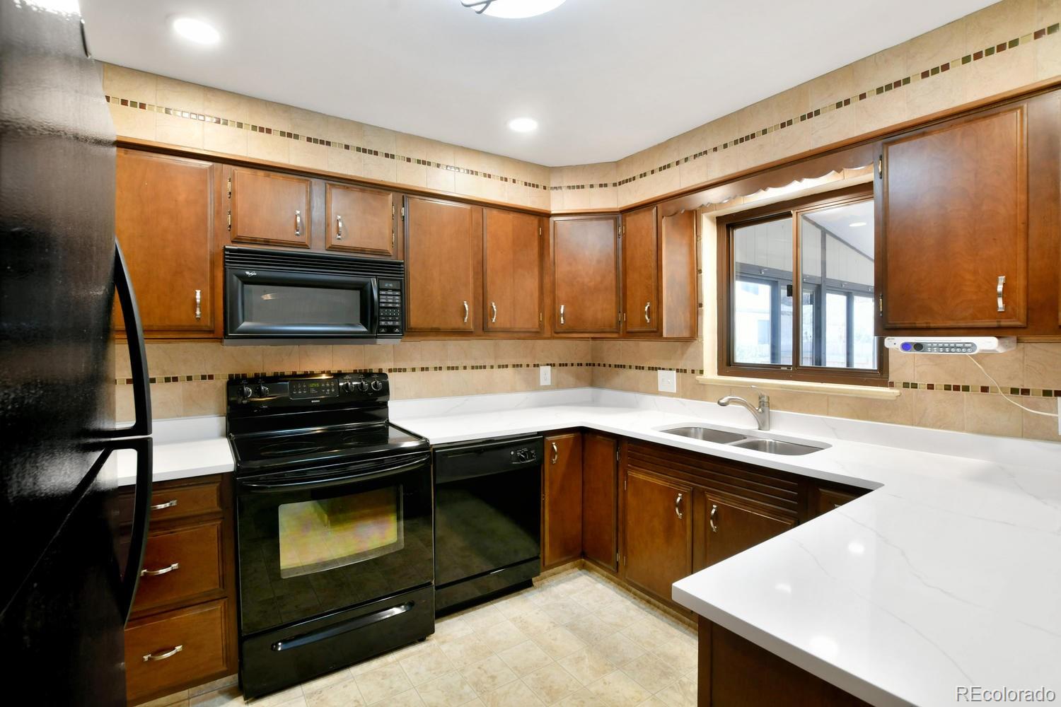 4660 Quay Street Wheat Ridge, CO 80033 - Photo 12 of 37 a kitchen with a sink stove and microwave