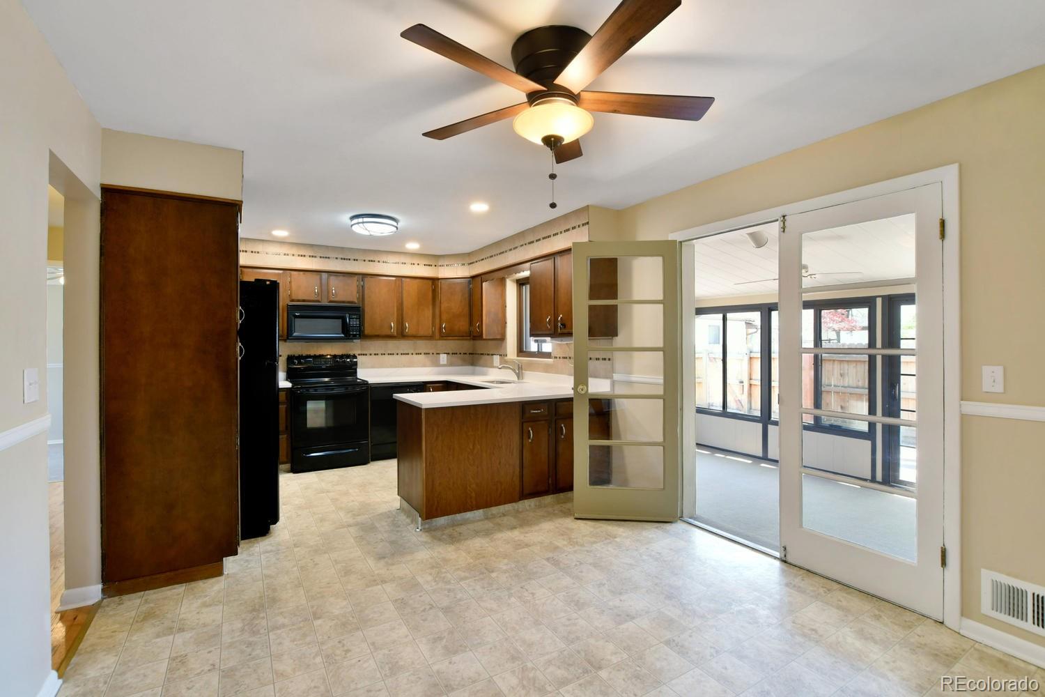 4660 Quay Street Wheat Ridge, CO 80033 - Photo 13 of 37 a kitchen with stainless steel appliances kitchen island granite countertop a refrigerator a sink a stove and a cabinets