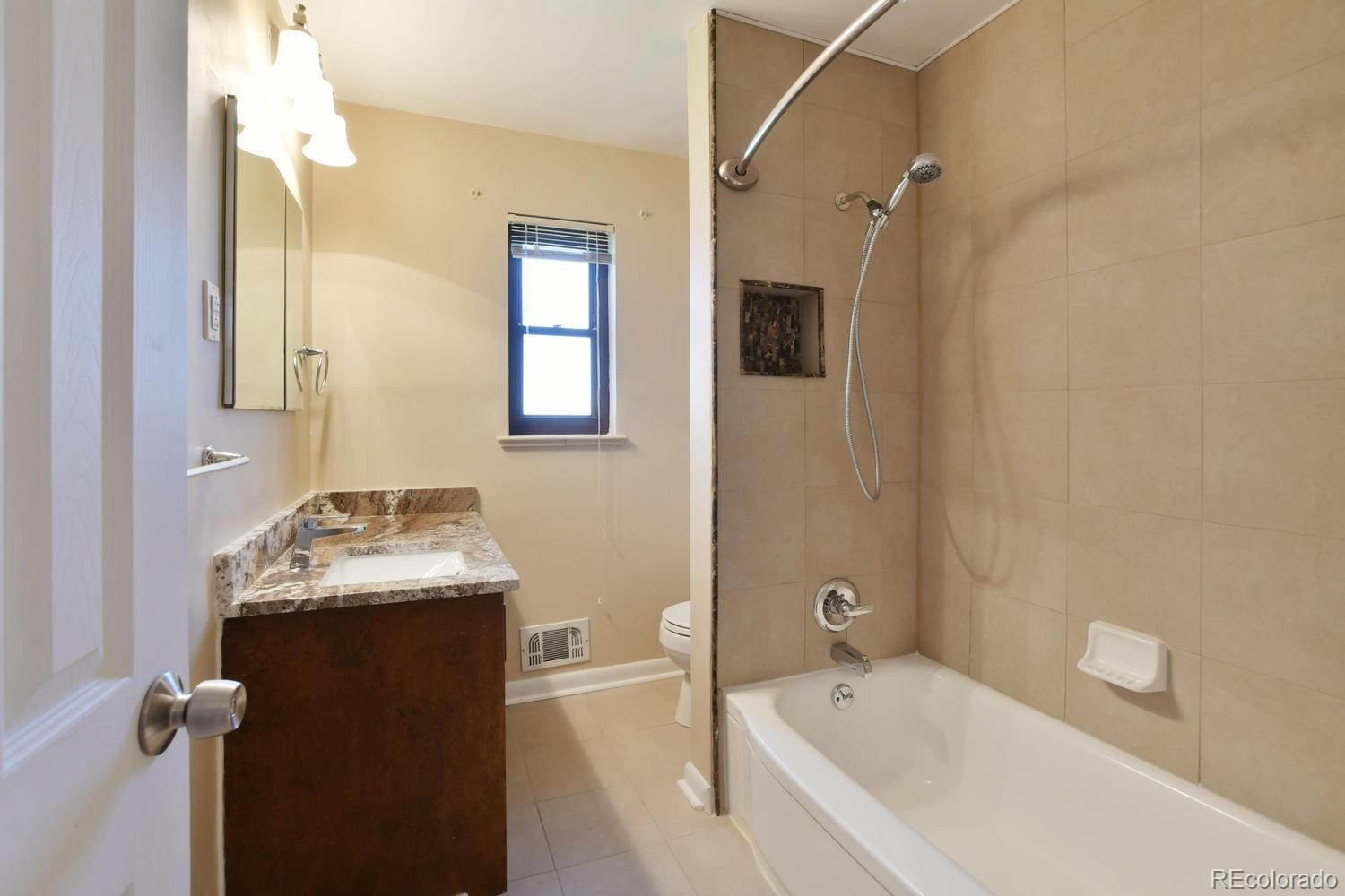4660 Quay Street Wheat Ridge, CO 80033 - Photo 28 of 37 a bathroom with a tub sink and mirror