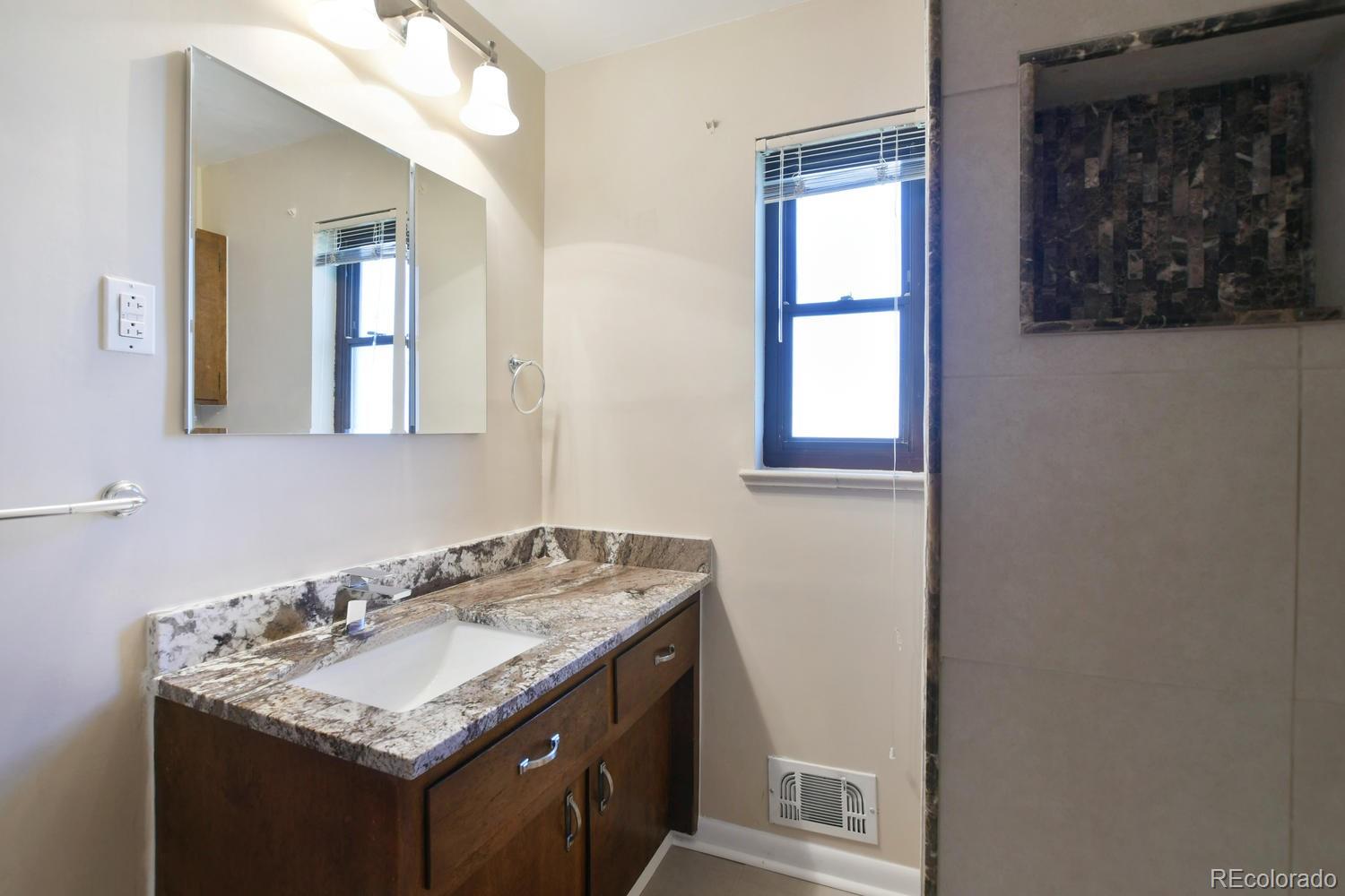 4660 Quay Street Wheat Ridge, CO 80033 - Photo 29 of 37 a bathroom with a granite countertop sink and a mirror