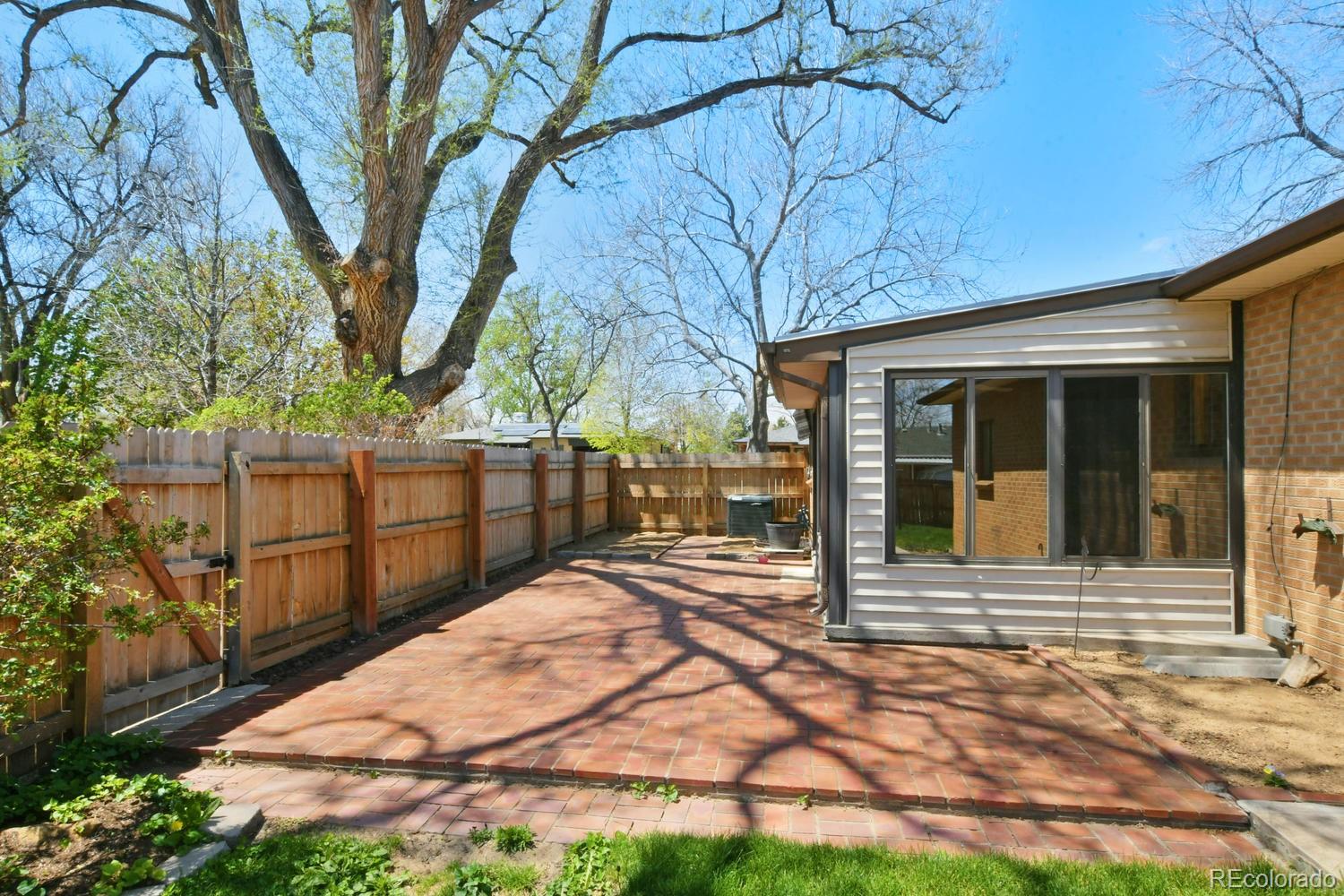 4660 Quay Street Wheat Ridge, CO 80033 - Photo 33 of 37 a view of a house with a small yard and wooden fence