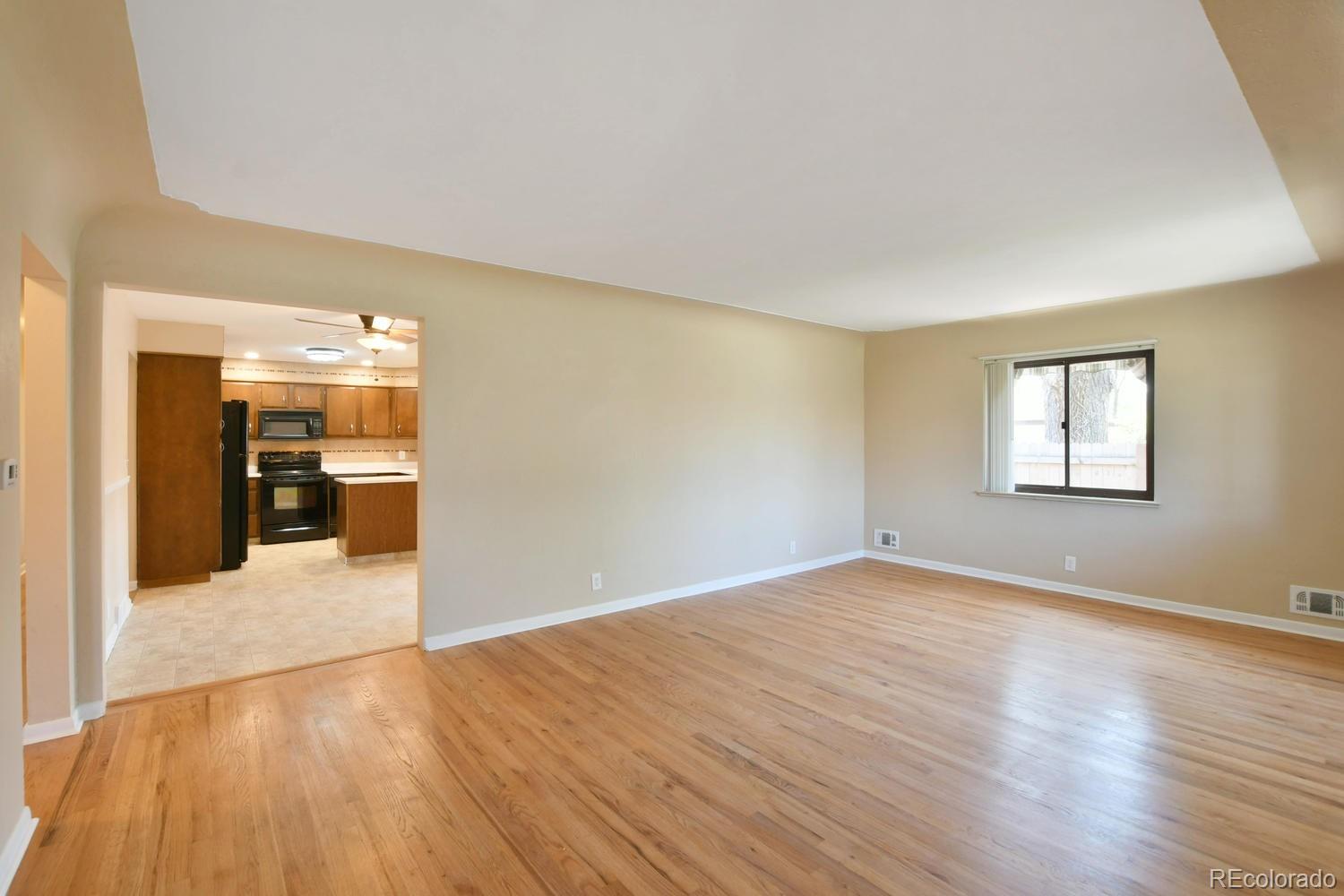 4660 Quay Street Wheat Ridge, CO 80033 - Photo 4 of 37 a view of a big room with wooden floor and a kitchen