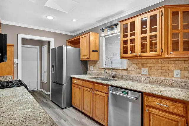 a kitchen with stainless steel appliances granite countertop a refrigerator and a sink