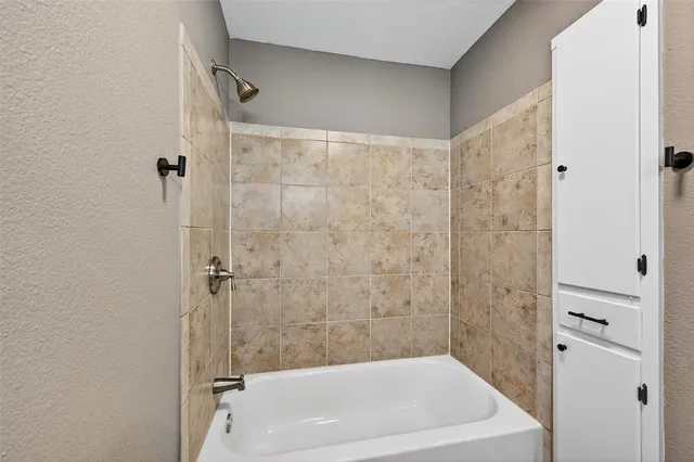 a bath tub sitting next to a white sink and a shower