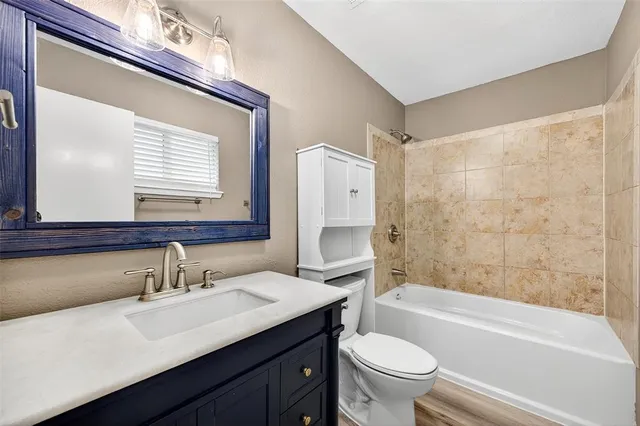 a bathroom with a sink a toilet a mirror and shower