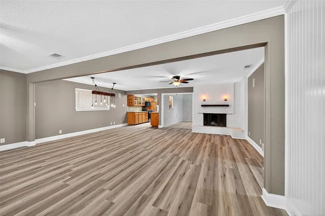 a view of empty room with a fireplace and wooden floor